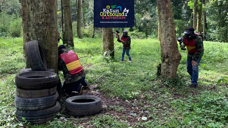 paintball Tim kantor berdiskusi strategi di balik bunker arena paintball hutan pinus Batu