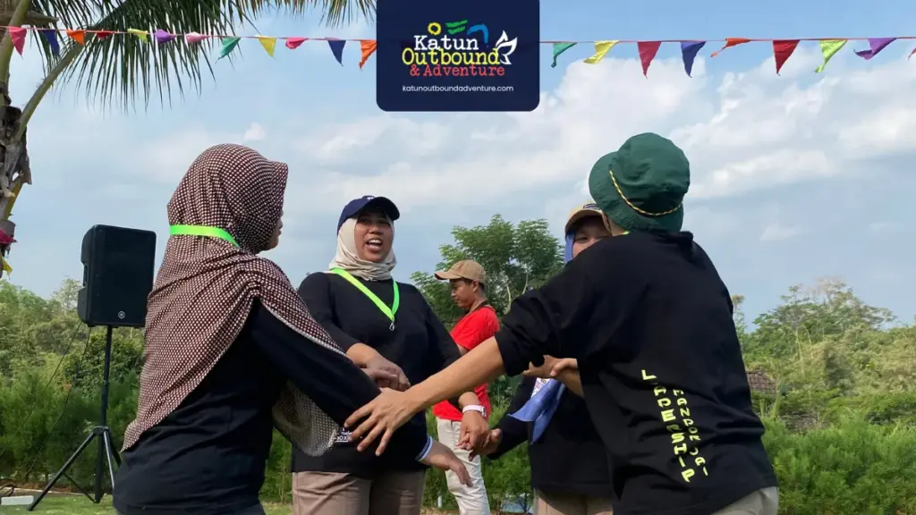 Karyawan bermain simulasi kelompok outbound di lapangan terbuka Kota Batu